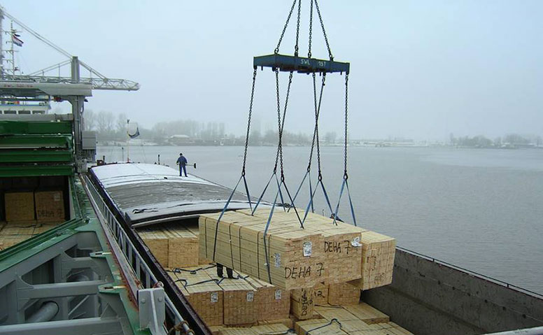 Handling of Forest Products: A cargo ship being loaded with forestry products at Emden Outer Harbor using a crane Handling of Forest Products: A cargo ship being loaded with forestry products at Emden Outer Harbor using a crane